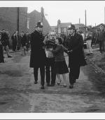 The greetings card of of Josie Smith, a retired and siabled miner, being escorted by police officers after being arrested outside his back gate. His wife is appealing for him to be released.