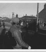 Greetings card of pickets gestitulacing to working miners in a coach on Station Road, Easington Colliery, County Durham, during February 1985.